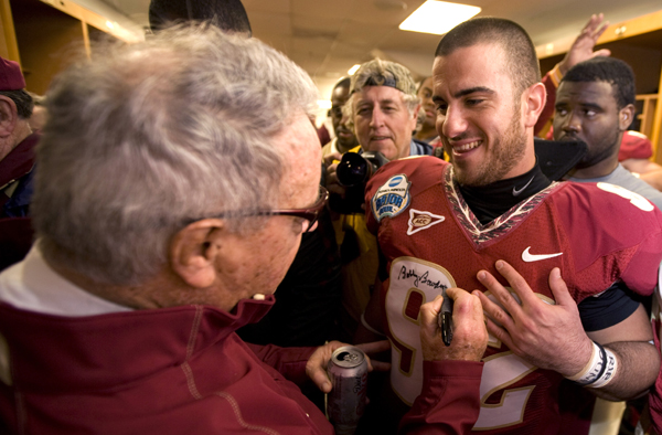 Bowden autographs his player's jersey's in the locker room after winning the Gator Bowl